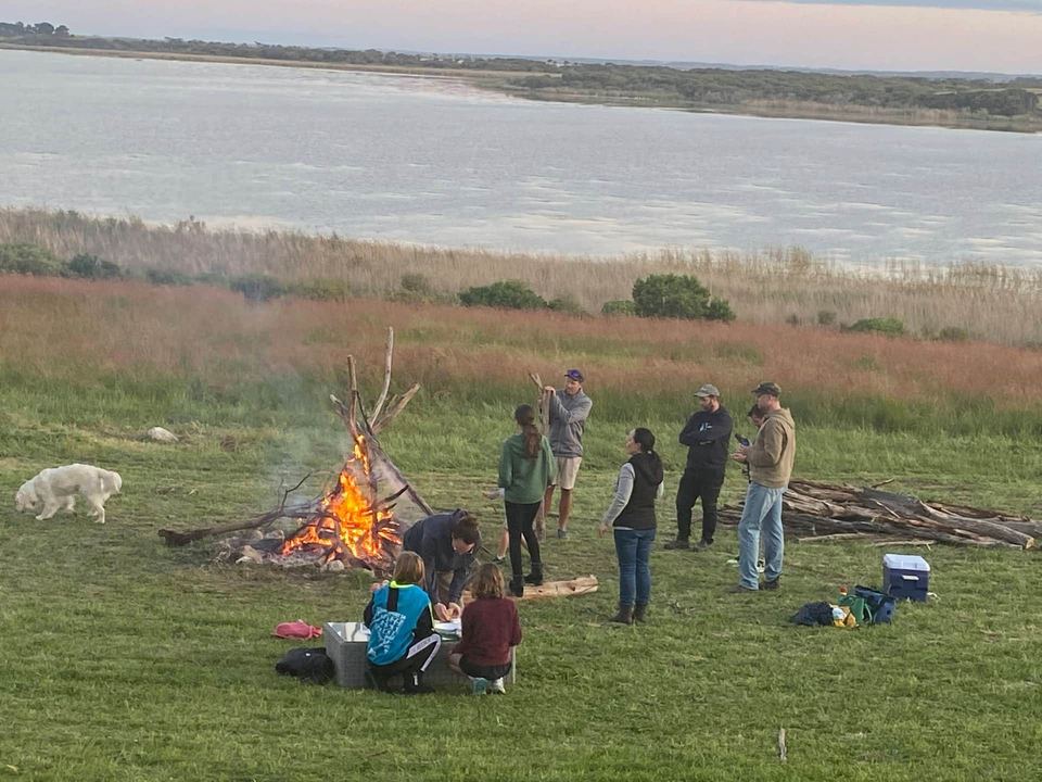 Group of friends around a campfire on the lawn